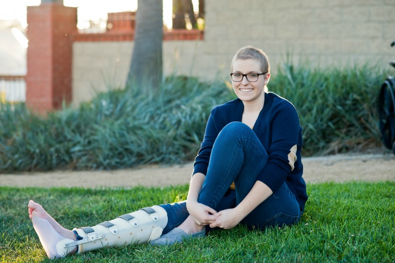 Emily smiles while sitting on the grass