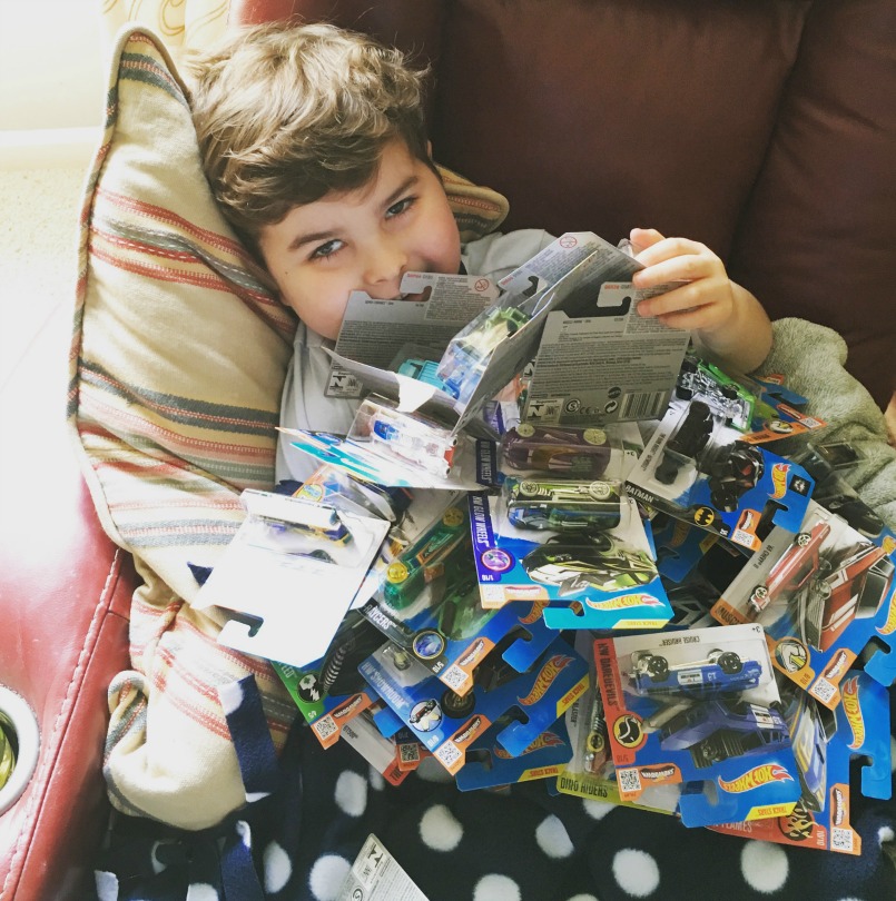 Brooks smiles under a pile of Hot Wheels