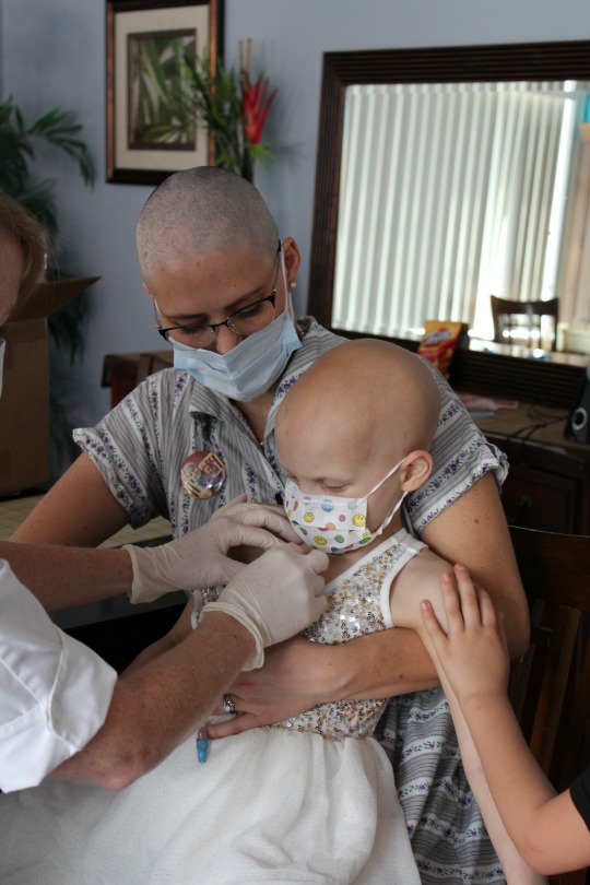 Hazel is held by her mom as she gets her chemo