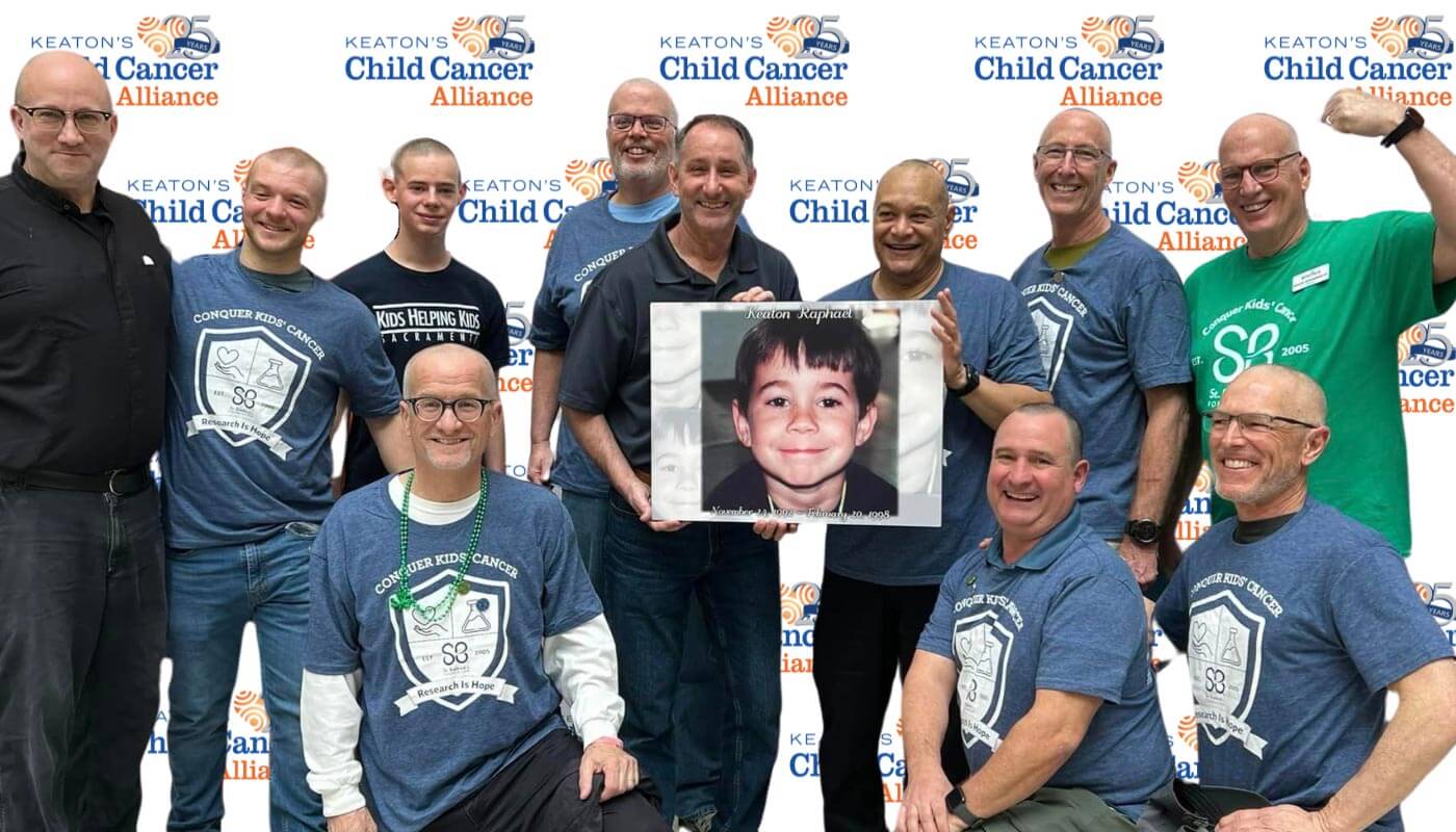 Photo of volunteers who shaved their head for Keaton's Child Cancer Alliance holding a photo of Keaton